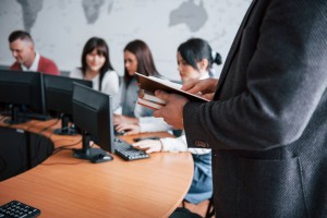 Holding notebooks. Group of people at business conference in modern classroom at daytime